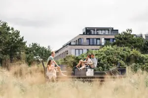 A group of people are sitting on a bench outside.