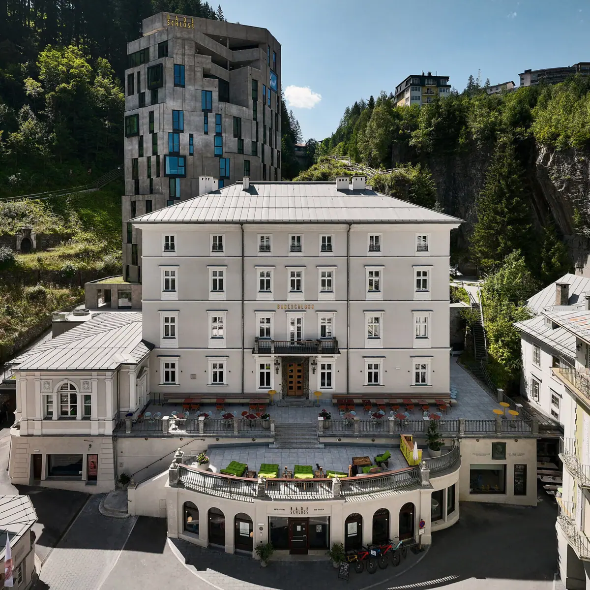 Bad Gastein Urban Nature A building with a large balcony and a large building with trees in the background.