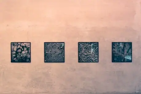 Vier Schwarz-Weiß-Fotos hängen an einer beigen Wand.