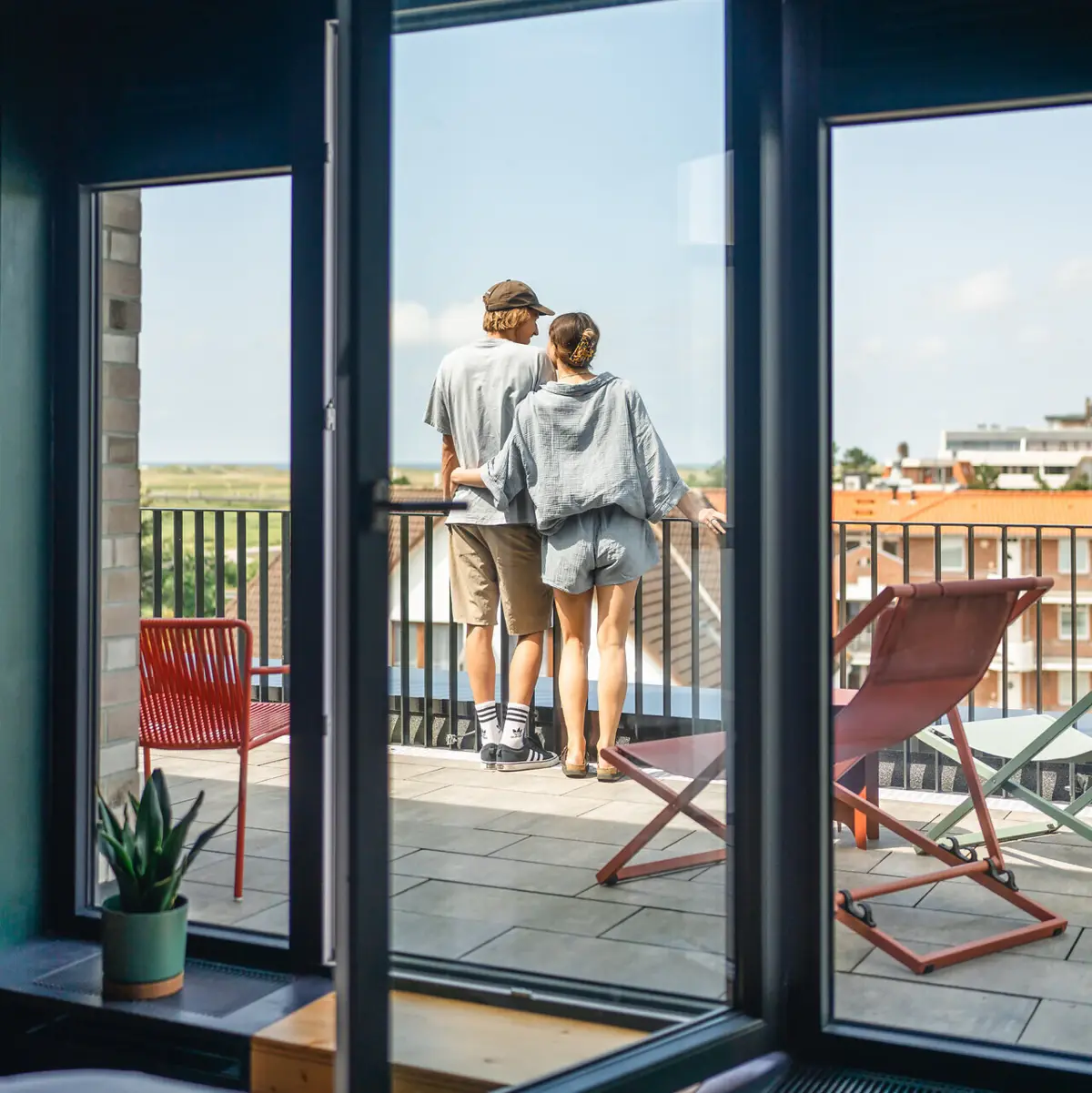 Eine Frau und ein Mann stehen auf einem Balkon und genießen die Aussicht.