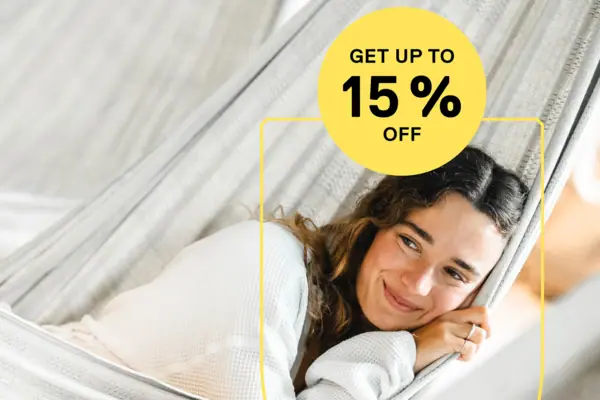 Low Season Offer A woman is lying in a hammock, smiling.