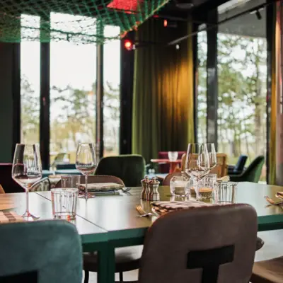 A table set in a restaurant with various glasses and cutlery.