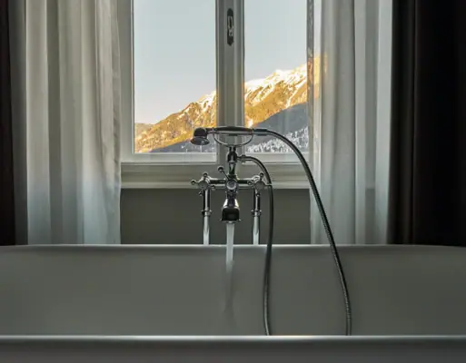 A bathtub stands in front of a window.
