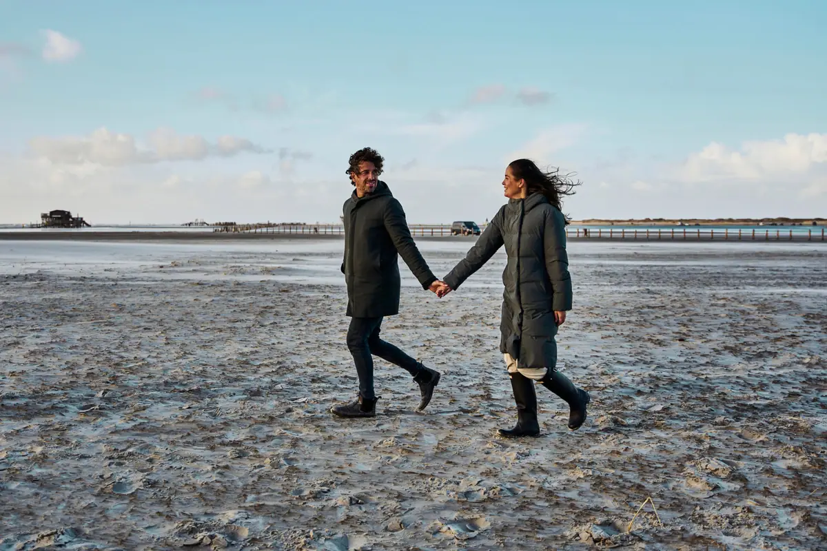 Mudflat hiking in St. Peter-Ording A couple holding hands while hiking on the mudflats in St. Peter-Ording.
