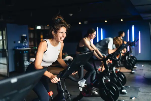 Eine Gruppe von Menschen auf Peloton Bikes beim Indoor-Cycling im Urban Nature St. Peter-Ording.