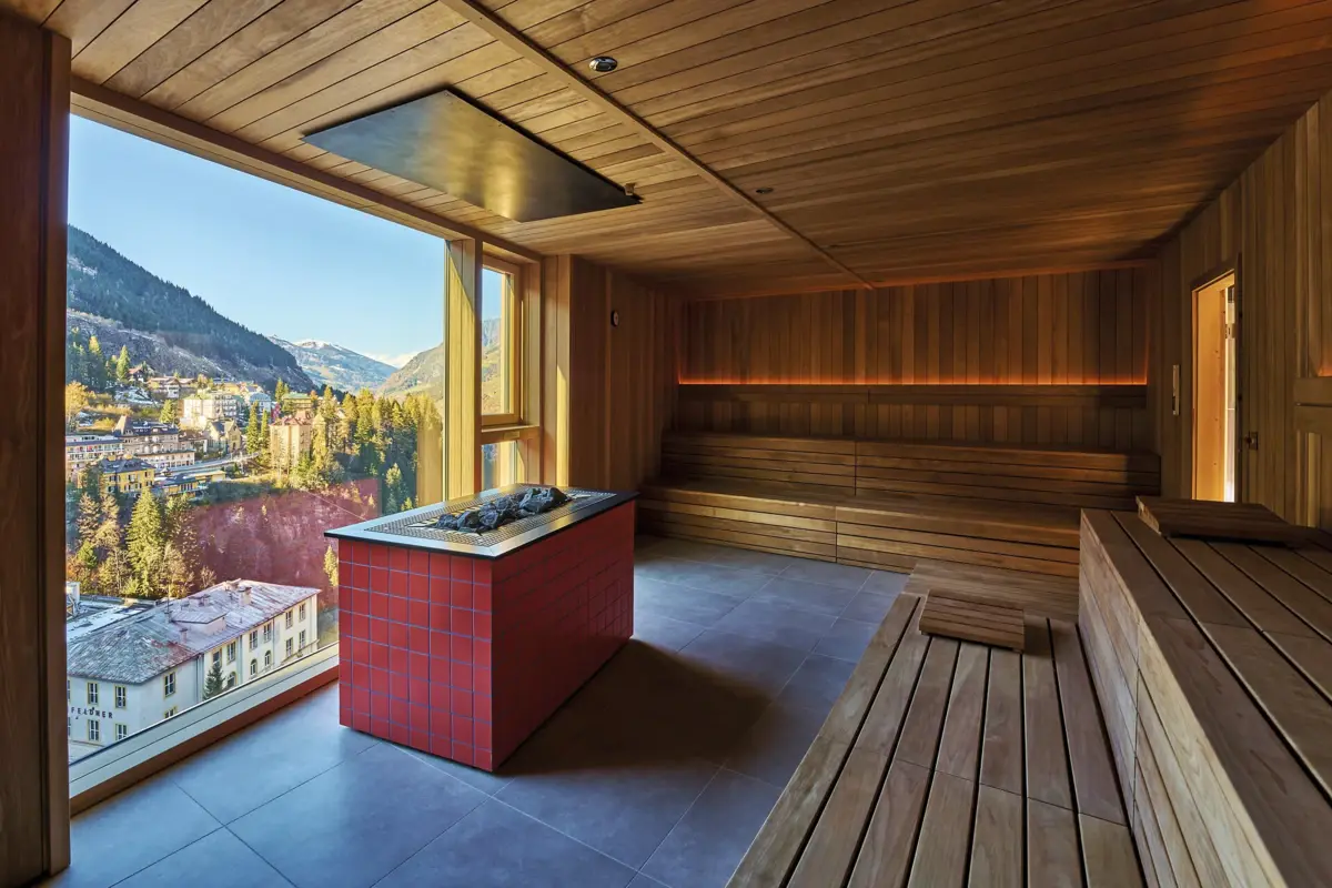 A sauna with a large window and a fireplace.