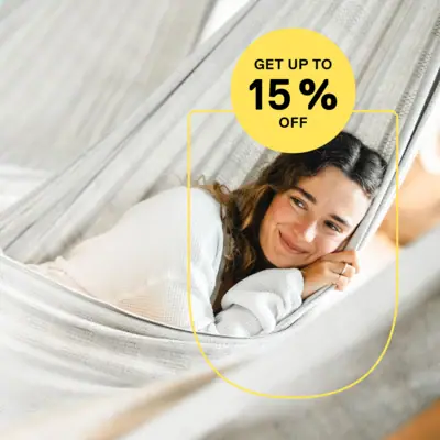A smiling woman is lying in a hammock.