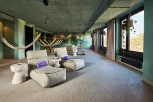 A room with hammocks and chairs.