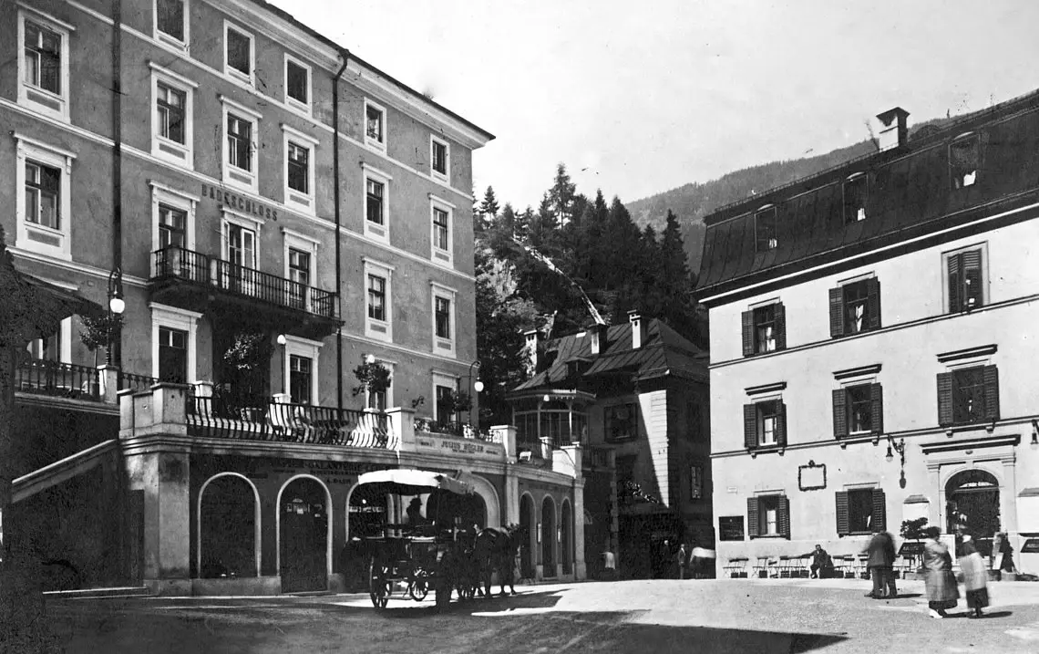 An old black and white photo of a square with houses around it.