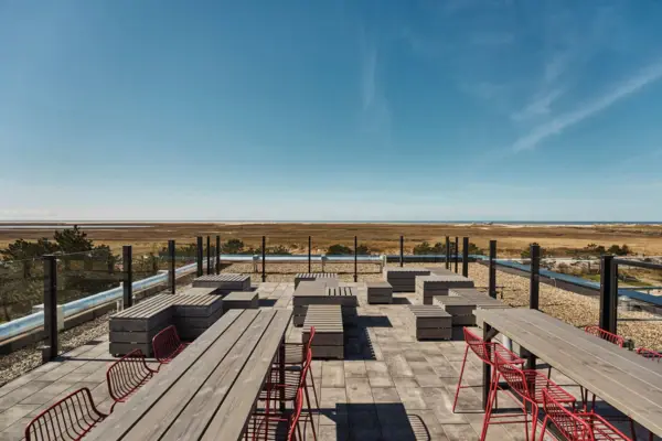 A terrace with a few tables and benches overlooking the salt marshes and the North Sea in St. Peter-Ording.