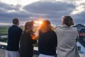 A group of people are standing outside with drinks.