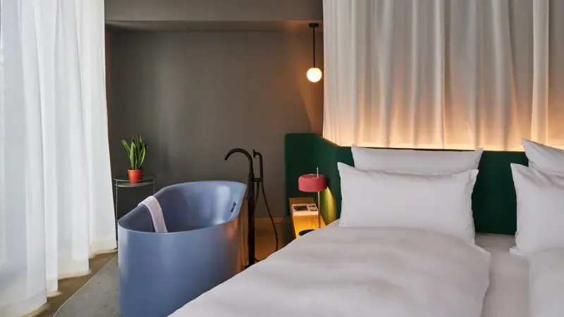 Zimmer mit Badewanne Ein Bett mit einer Badewanne und einer Lampe in einem stilvoll eingerichteten Raum.