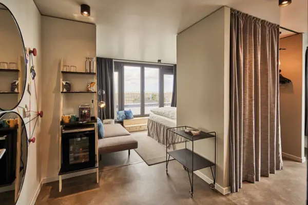 Suite A suite at the Urban Nature Hotel St. Peter-Ording with large windows and a terrace.