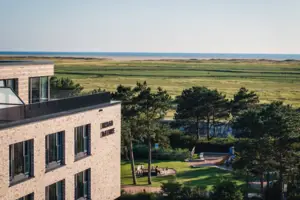 A building with a playground and a grass field.