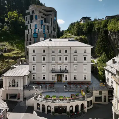 Urban Nature Bad Gastein Das Urban Nature Hotel Bad Gastein von außen mit den Bergen im Hintergrund.