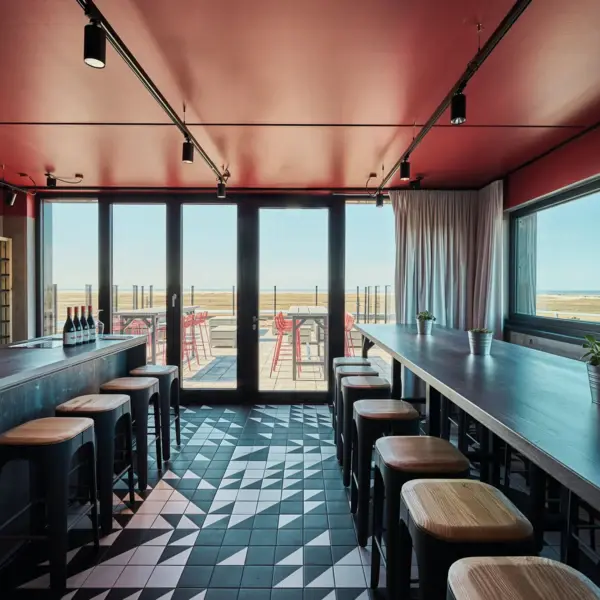 A bar with a row of stools and a roof terrace in the background.