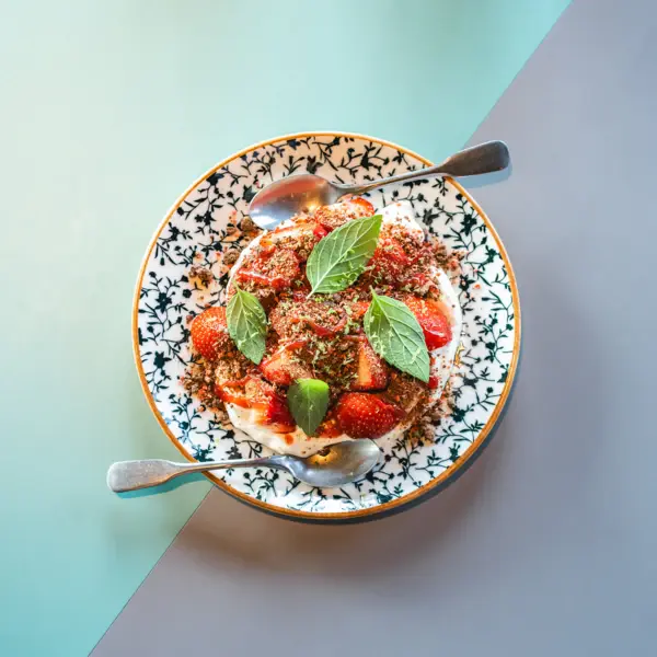 A plate dish photographed from above with tomatoes and basil.