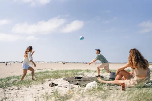 A group of people are playing with a ball on the beach.