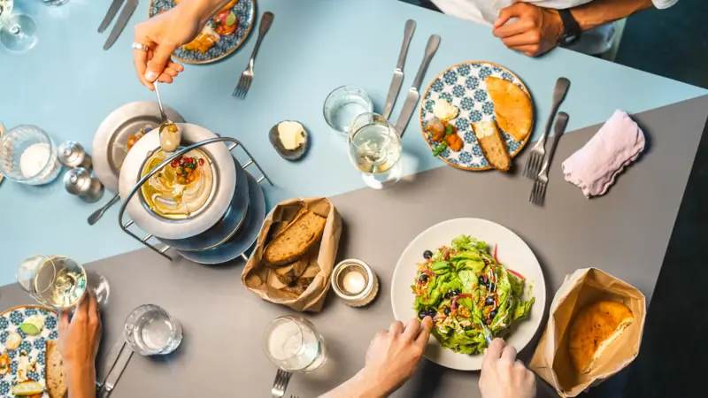 A table with lots of plates and delicious food photographed from above.