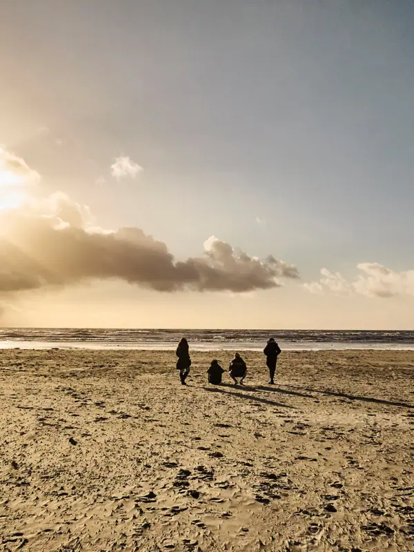 People are walking along the beach.