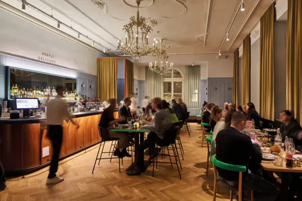 Eine Gruppe von Menschen sitzt an Tischen in einem Restaurant.