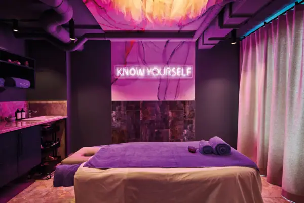 Treatments and Massages Urban Nature St. Peter-Ording Purple room with a massage table and towel at the Urban Nature Hotel St. Peter-Ording.