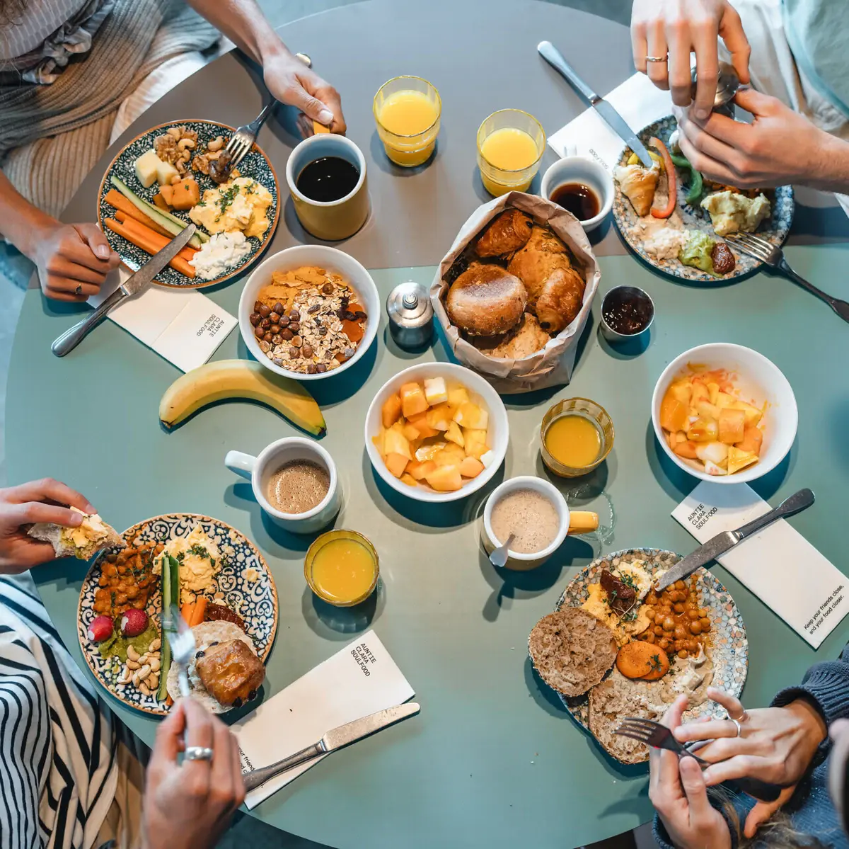 Overhead shot of a shared breakfast at Urban Nature St. Peter-Ording – relaxed morning moments with fresh food and friends.