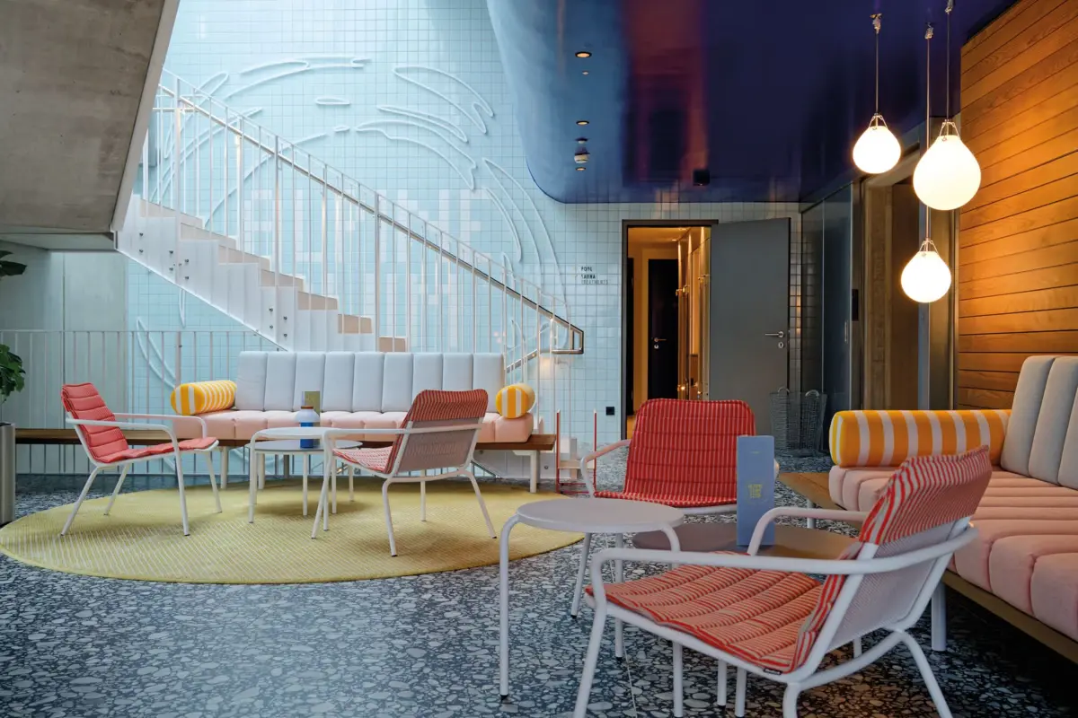 Alpine Swim Club entrance area Modern lounge area with colorful furniture, circular staircase, stylish wall design and cozy lighting concept