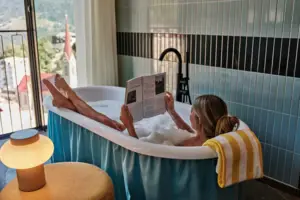 A woman is reading a book in the bath.