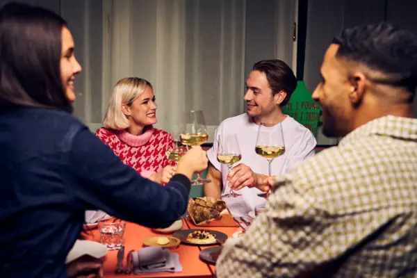 Eine Gruppe von Menschen sitzt um einen Tisch mit Weingläsern.