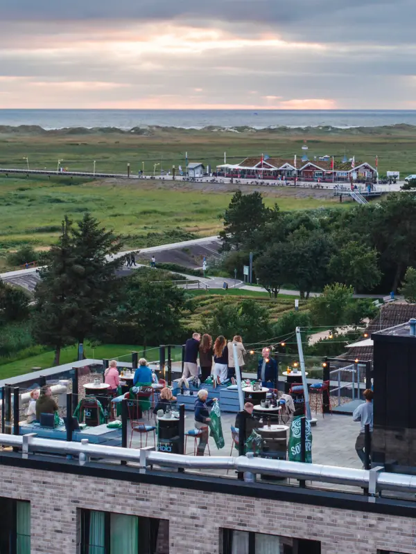 The Scraper's Club rooftop bar at the Urban Nature Hotel St. Peter Ording with the salt marshes and the North Sea in the background.