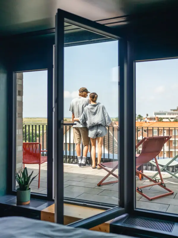 View from the balcony A couple are standing on the balcony of a room at the Urban Nature Hotel in St. Peter-Ording, looking out.