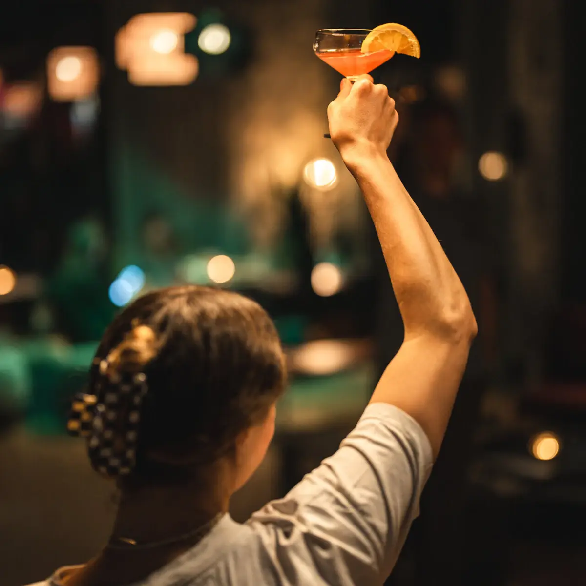 Raising a glass at Urban Nature – laid-back atmosphere, drink in hand, smile on her face.