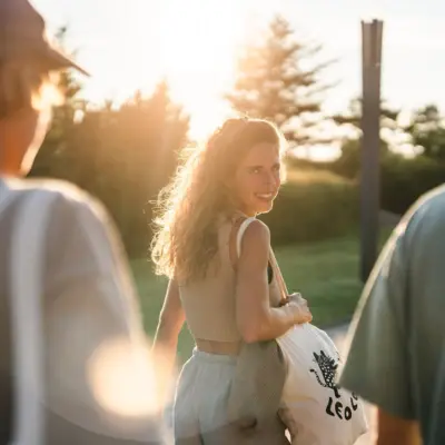A woman looks back over her shoulder at the camera and smiles.