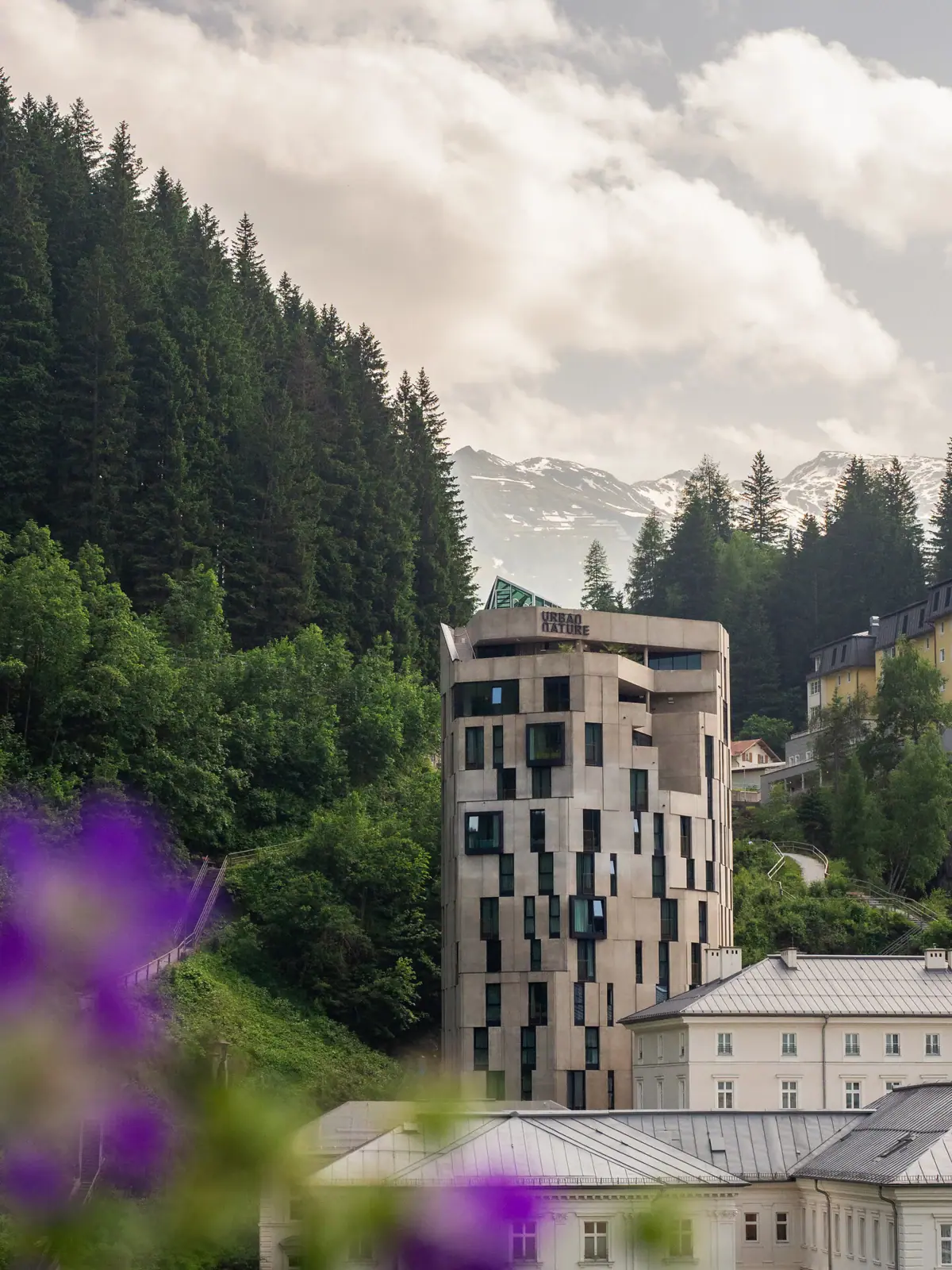 A building with trees and mountains in the background.