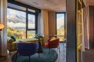 A room with a sofa and chairs.