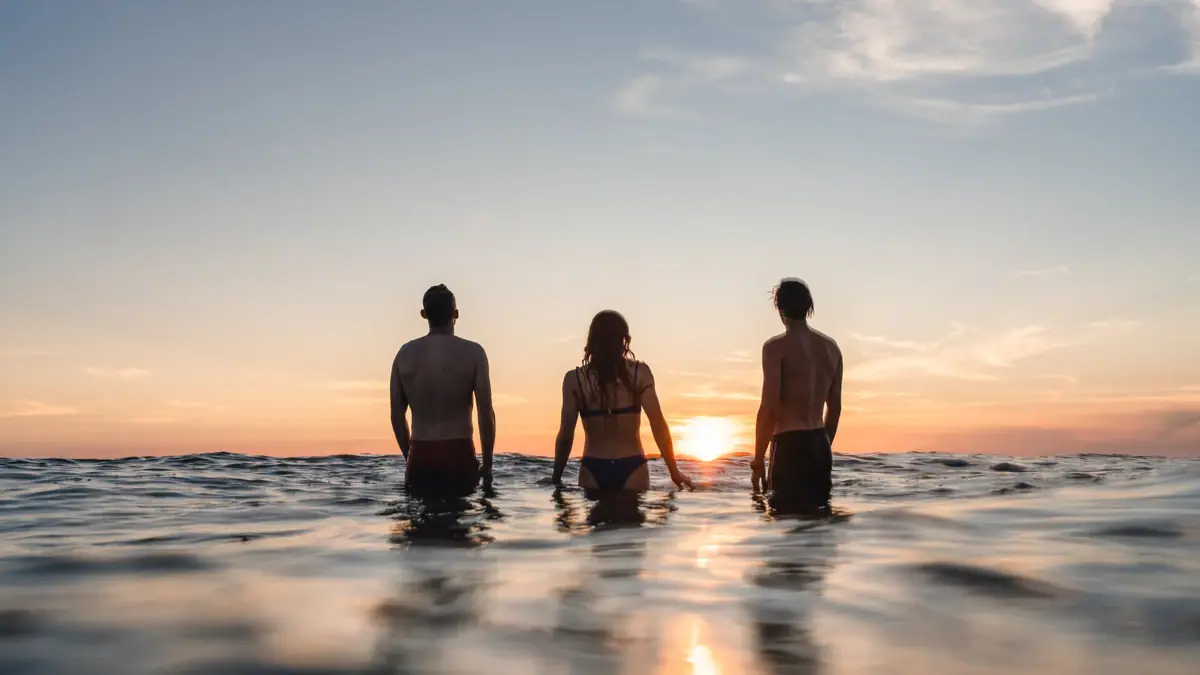 A group of people are standing in the water.
