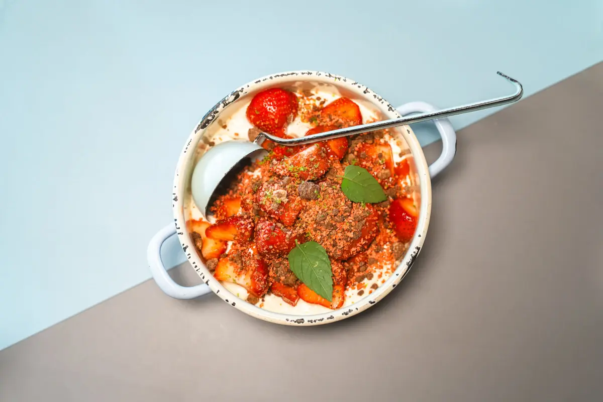 Plate Auntie Clara A small pot with a ladle and a delicious dish with tomatoes in it.