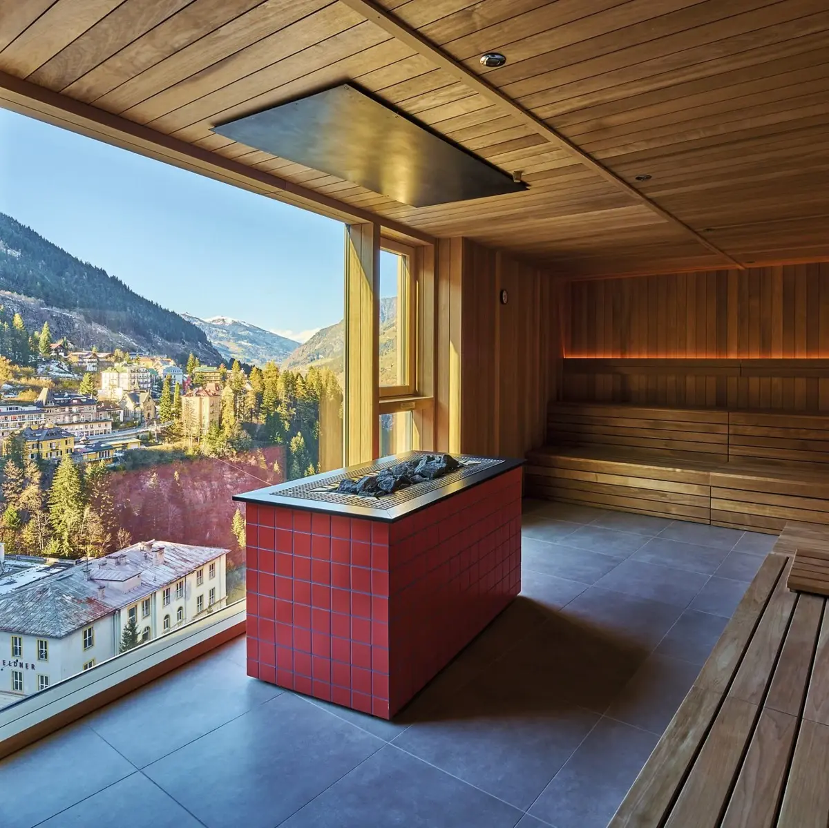 A sauna with large windows and a view of the mountains.