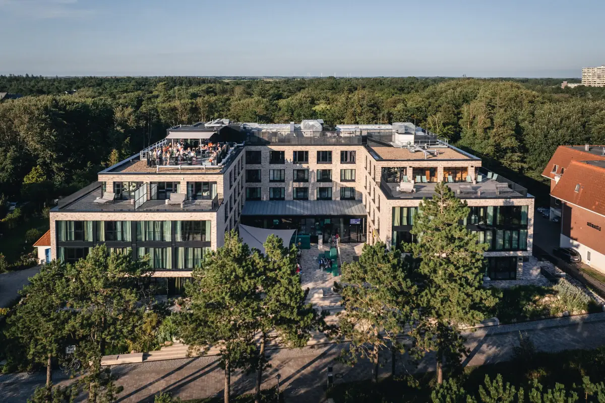 Das Urban Nature Hotel in St. Peter-Ording mit Bäumen im Hintergrund.