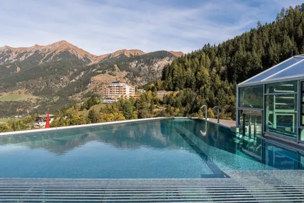 Swimming pool with a building and mountains in the background