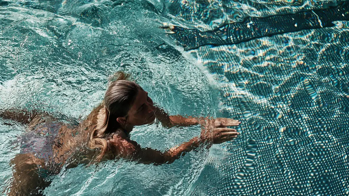 A woman is swimming in a pool.